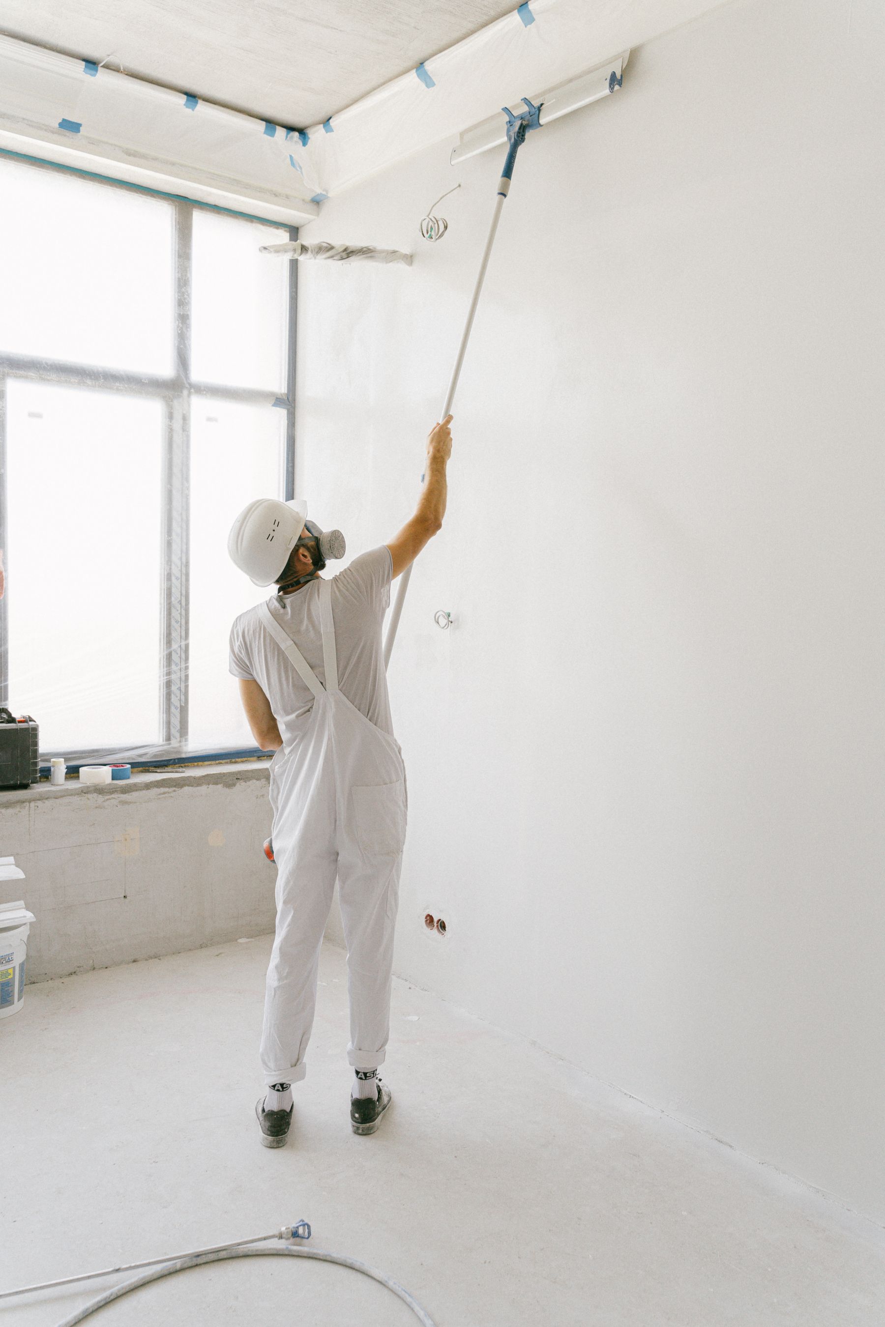 Painter using a roller on an interior wall